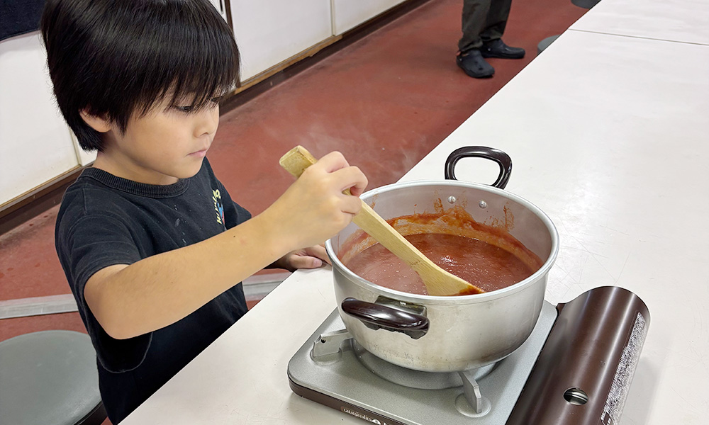 トマトケチャップを煮詰める子供