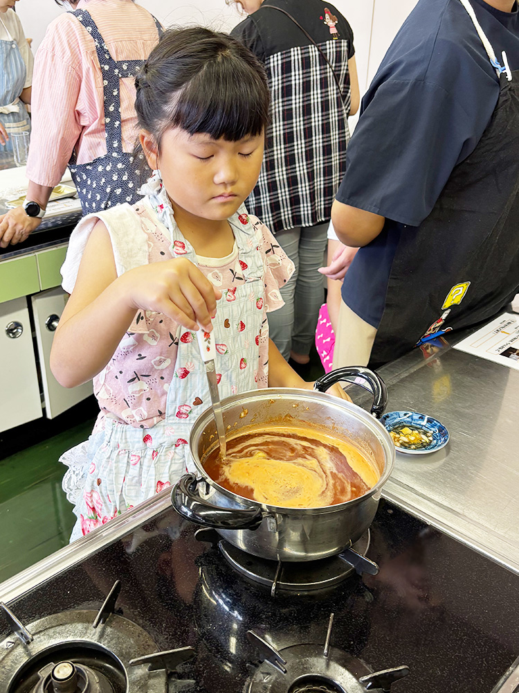 焼きそばソースを煮詰める子供