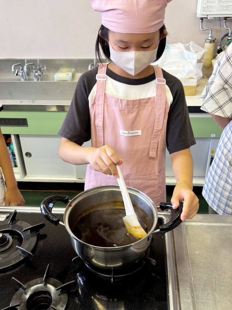 焼きそばソースを煮詰める子供