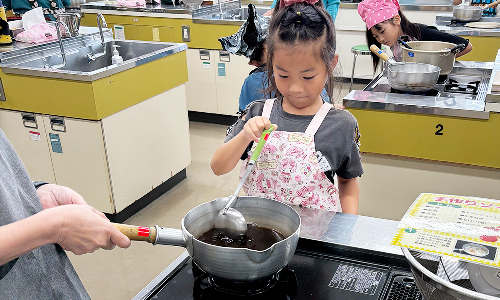 鍋をかき混ぜる子供