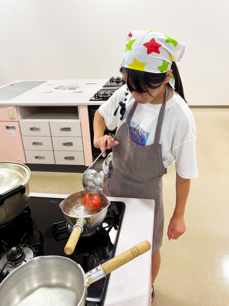 トマトを湯むきする子供