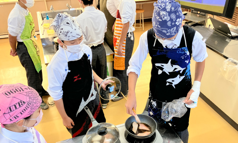 古知野中学校の出前講座 2025年魚の切り身を入れる様子