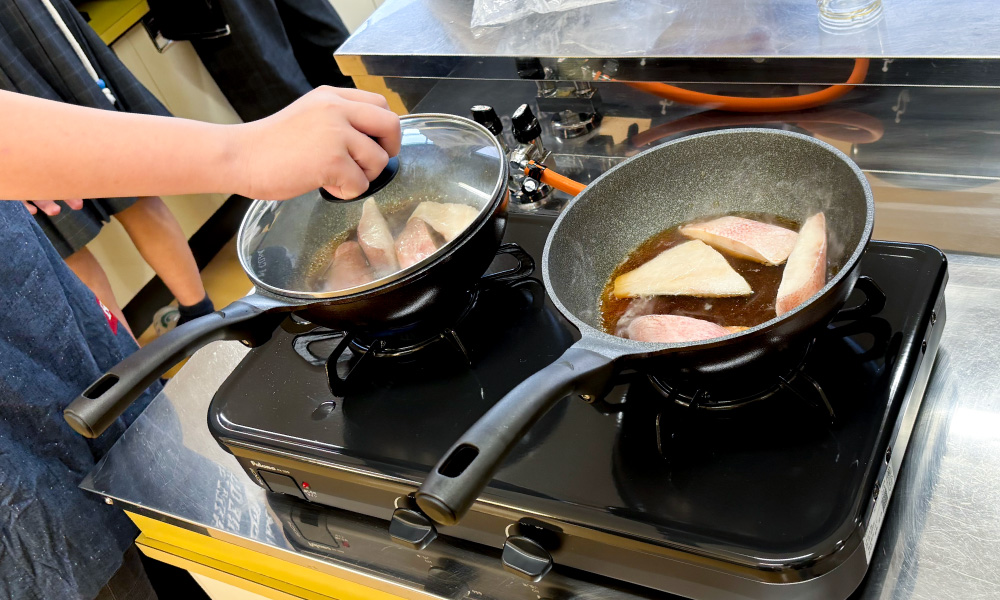 古知野中学校の出前講座 2025年 魚の切り身を煮詰める様子