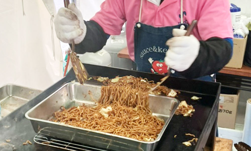 完成した焼そばをバットに移すところ